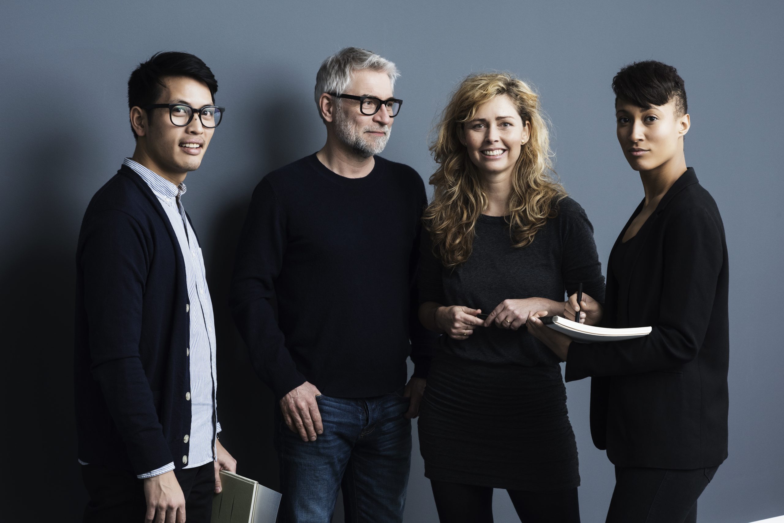 Portrait of men and women holding papers